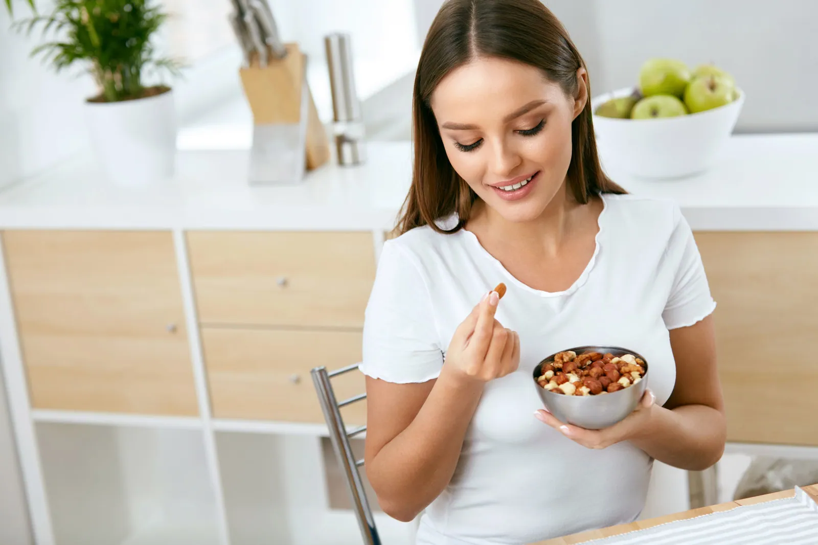 Healthy Food. Happy Woman Eating Nuts