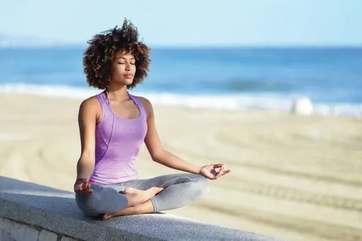 Woman meditating on beach