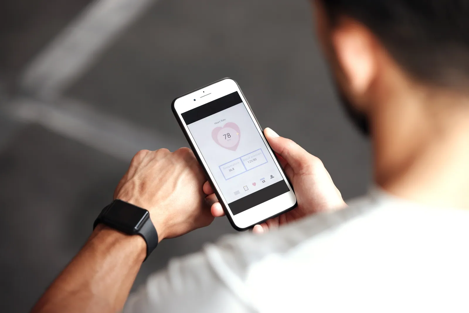 Man checking health stats on a smartwatch and phone