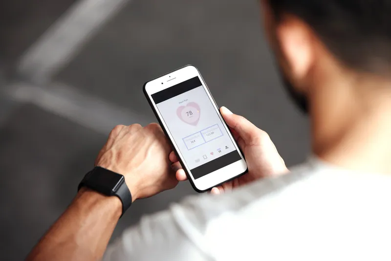 Man checking health stats on a smartwatch and phone